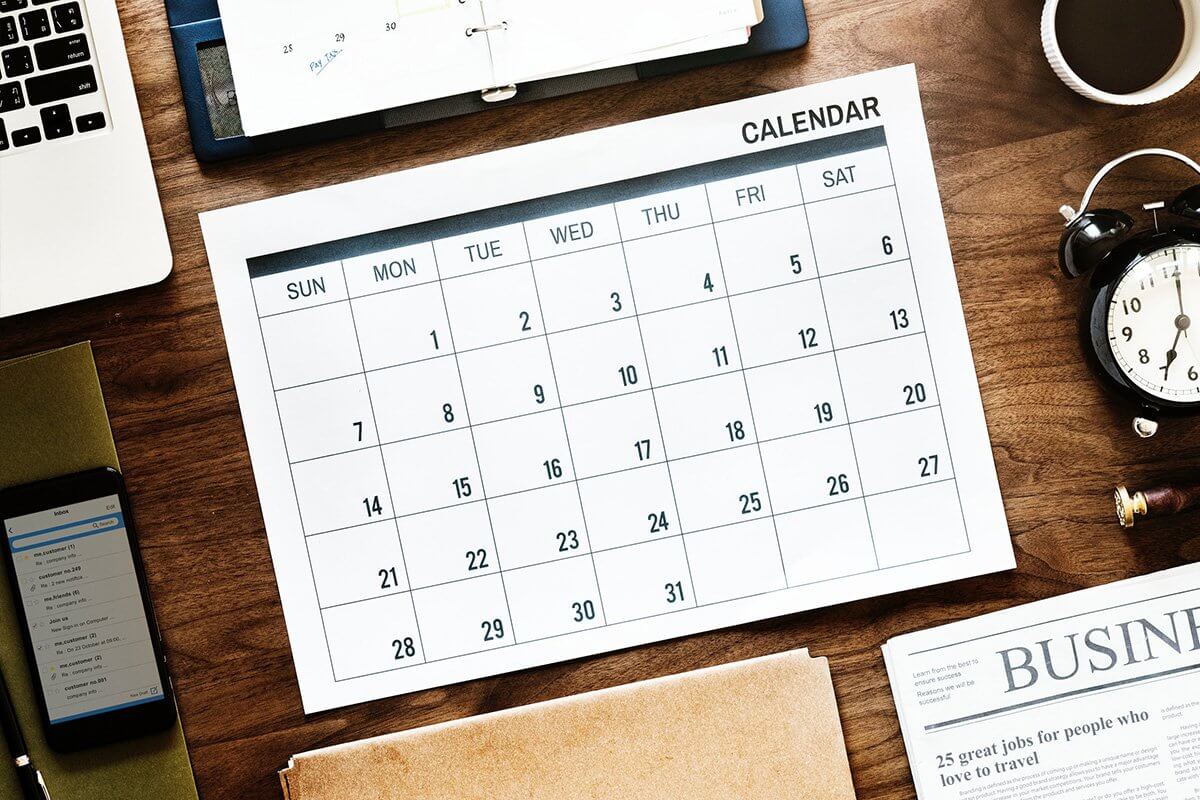 Ein kalender liegt auf einem gut organisierten Schreibtisch.